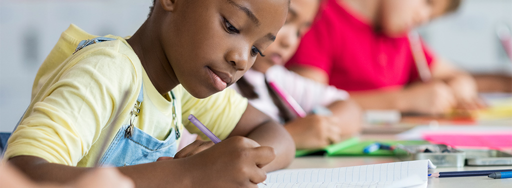 Comunidad Diversa, niña de raza negra escribiendo  en un cuaderno