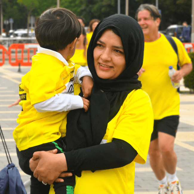 Mujer refugiada y bebé en Carrera Solidaria por la paz en León
